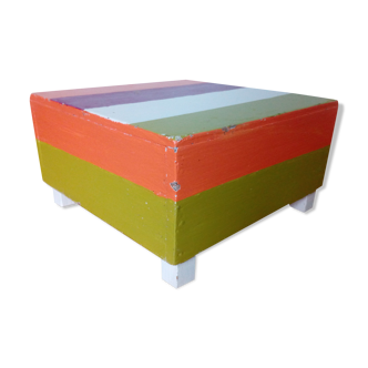 Low wooden stool painted in bright colours