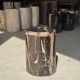 Black petrified wood side table with beige stripes and a semicircular shape.