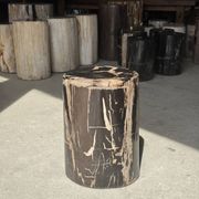 Black petrified wood side table with beige stripes and a semicircular shape.