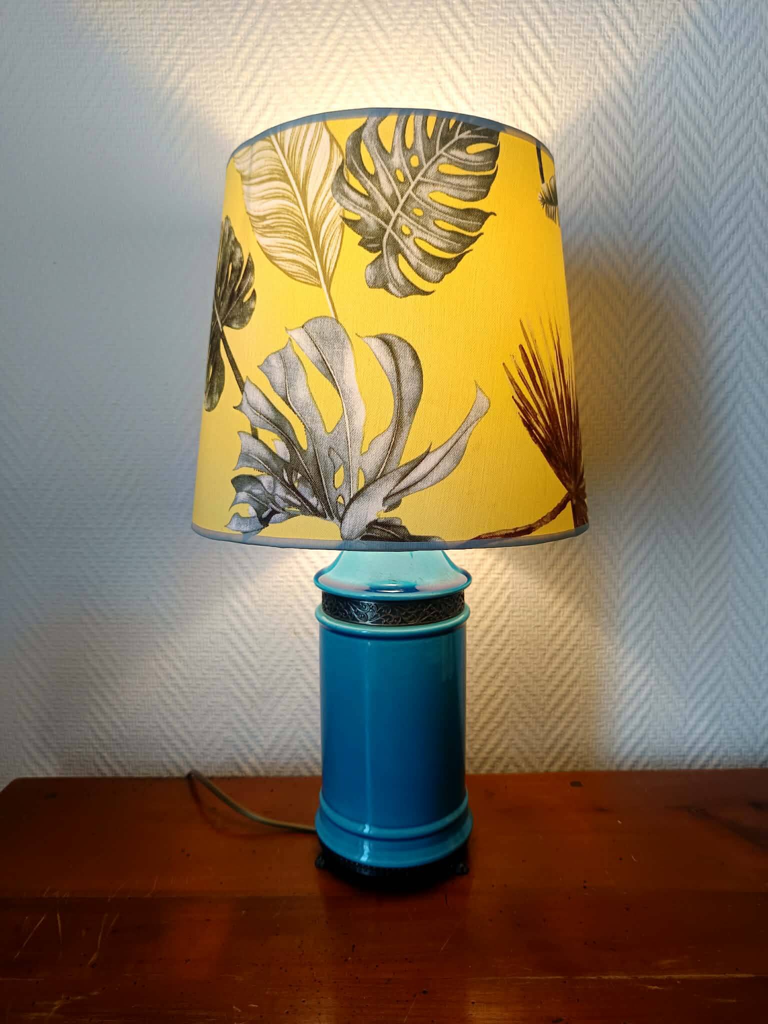 Blue ceramic lamp with claw feet and foliage lampshade.