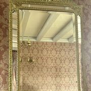A wall mirror in the Louis XVIII style.