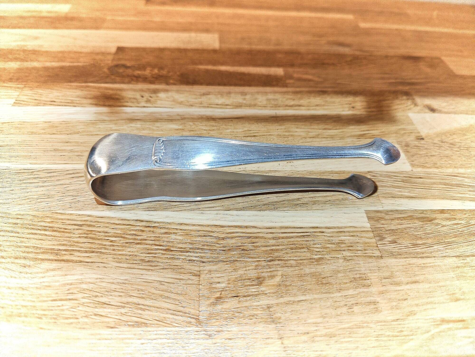 Antique sugar tongs in silvered metal