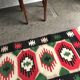 Fauteuil ancien en tissu rose et bois, dossier ajouré en cœur, pieds tournés