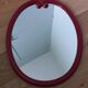 Oval mirror, red enamelled metal in Art Deco style, 49 x 39 cm.