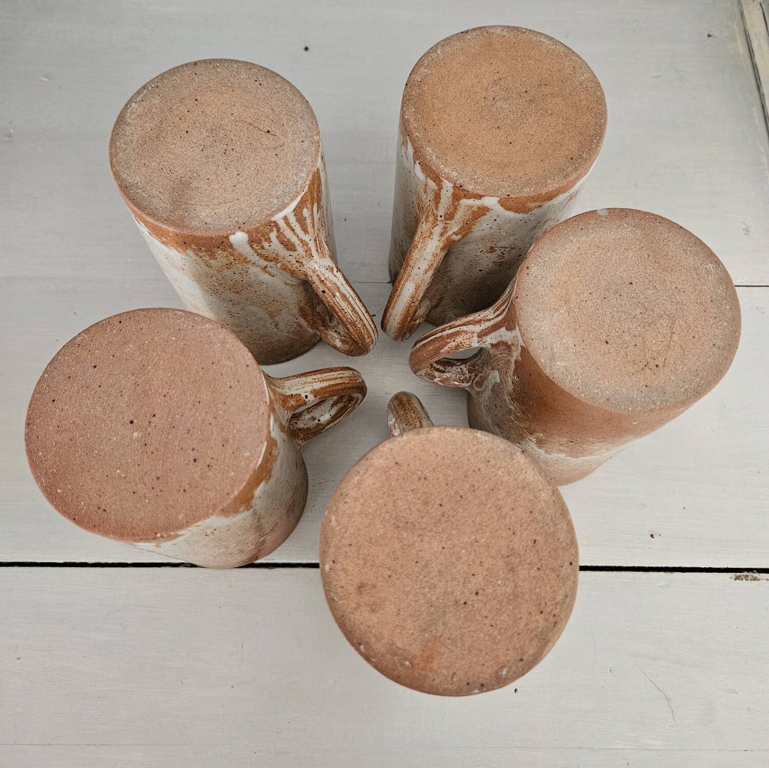 Set of 5 vintage handcrafted stoneware mugs in beige, pink, and white glazed stoneware