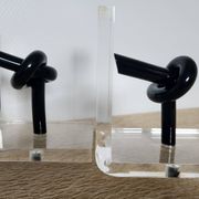 Bookends in plexiglass and knotted black tubes, 1980s design.