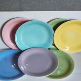 Seven pastel-colored plates mixed with vintage earthenware