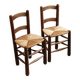 Pair of wooden chairs with woven straw seats.