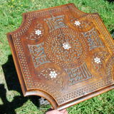 A folding chair and a carved Syrian table with 19th-century mother-of-pearl inlays.