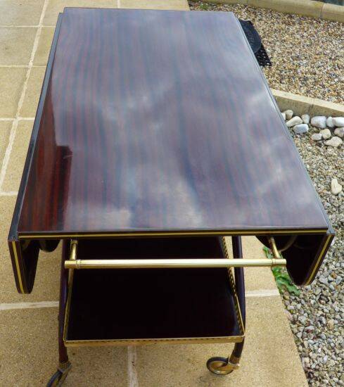 Chic serving table on wheels from the 60s with brass decorations and two shelves.