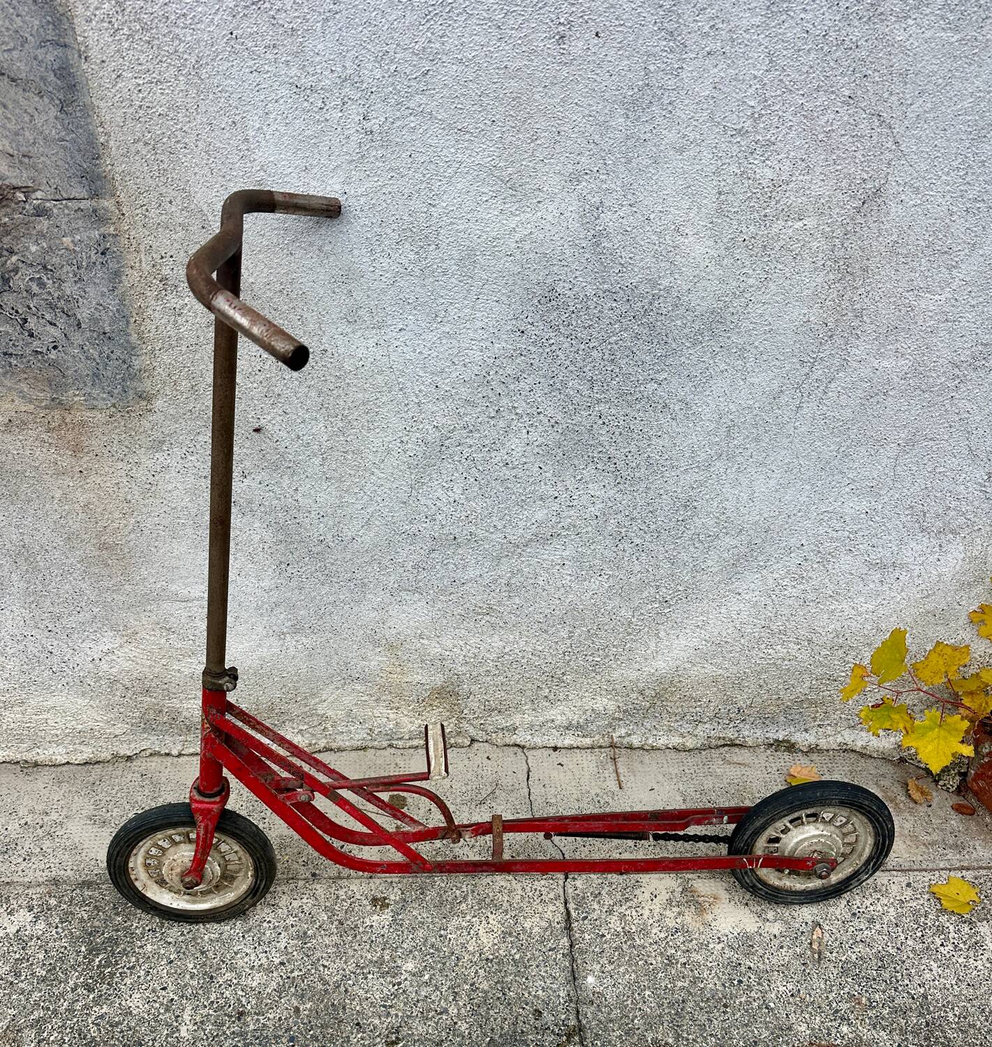 Trottinette rouge ancienne à pédale et chaîne