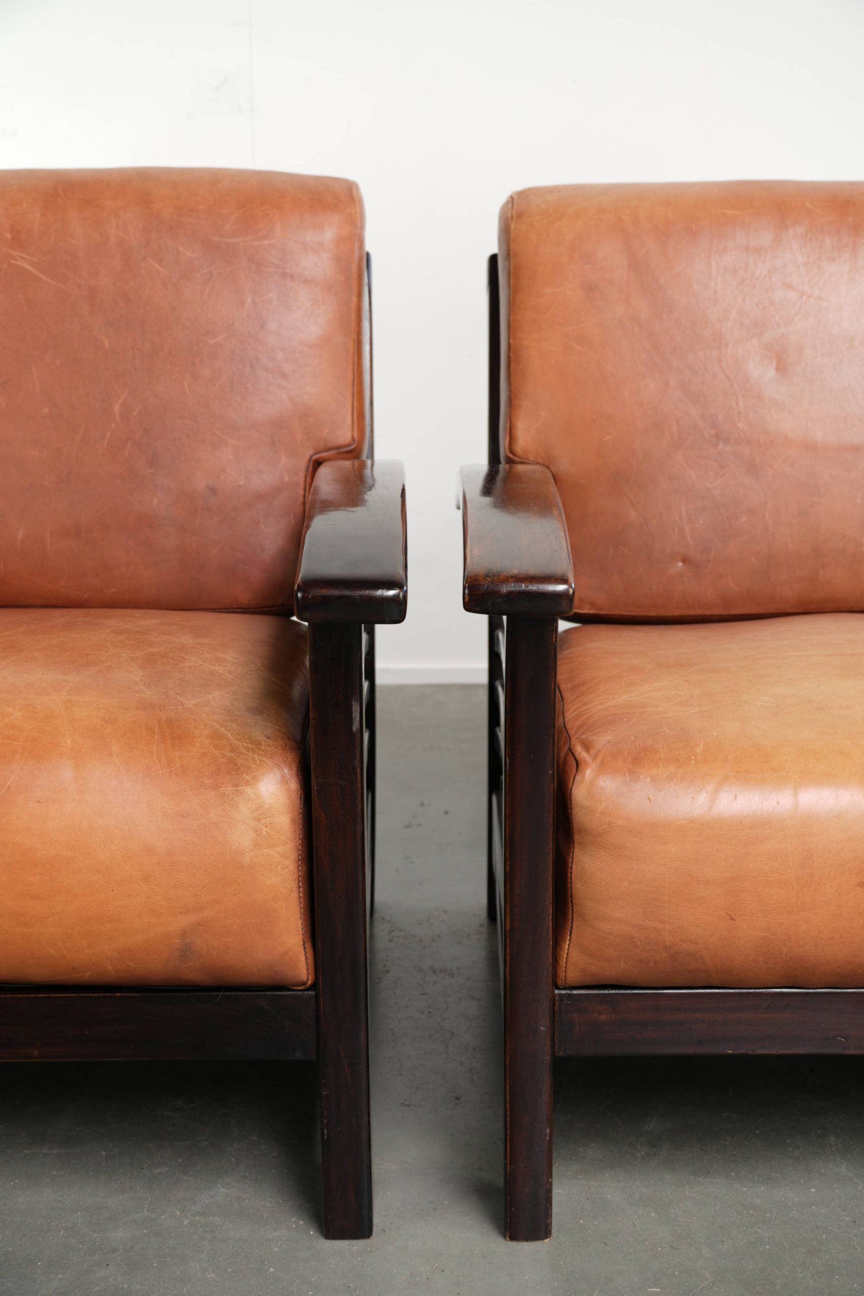 Ensemble de 2 fauteuils Art Déco en cuir de vache couleur cognac du 20e siècle.