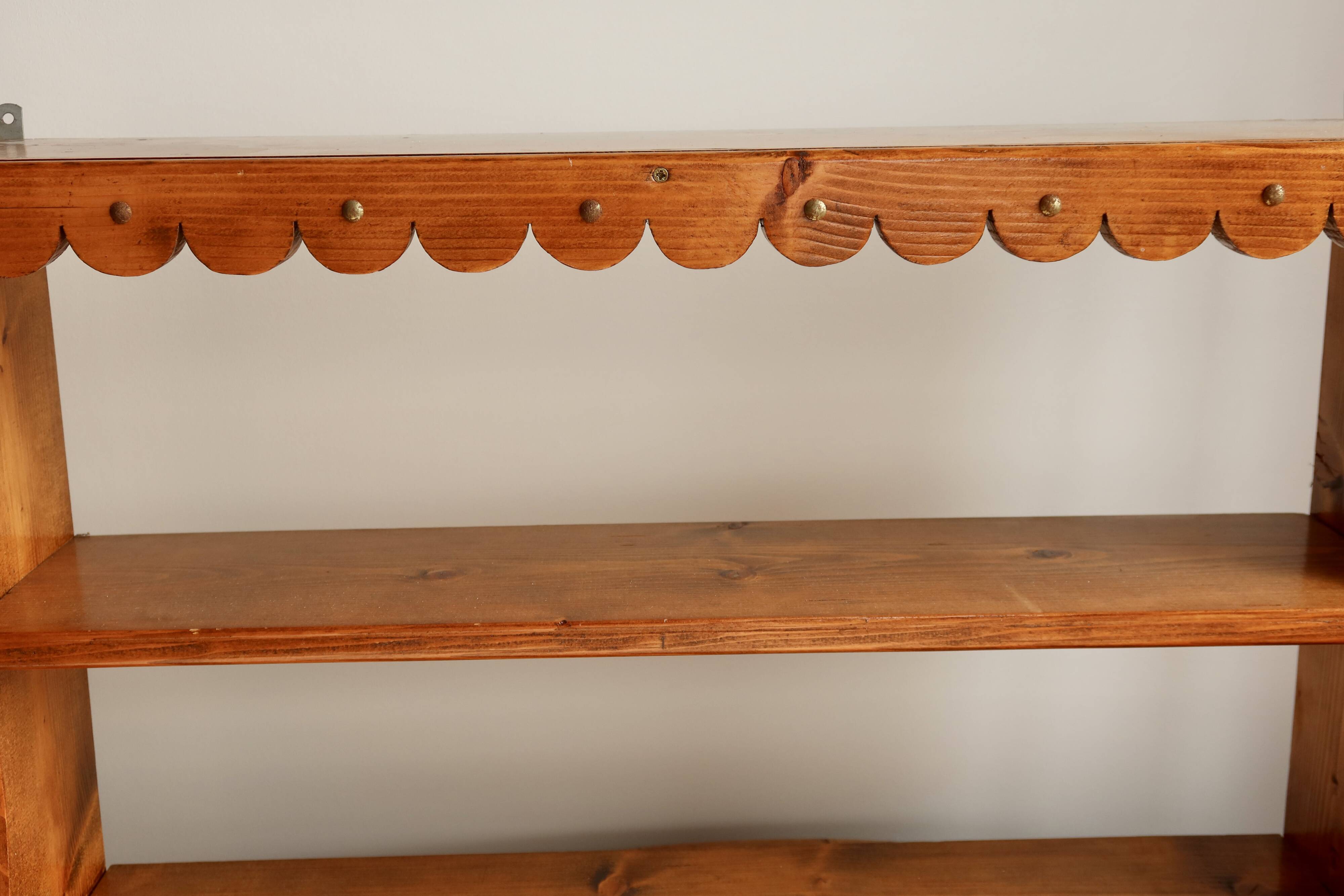Vintage pine wall shelf with a scalloped front.