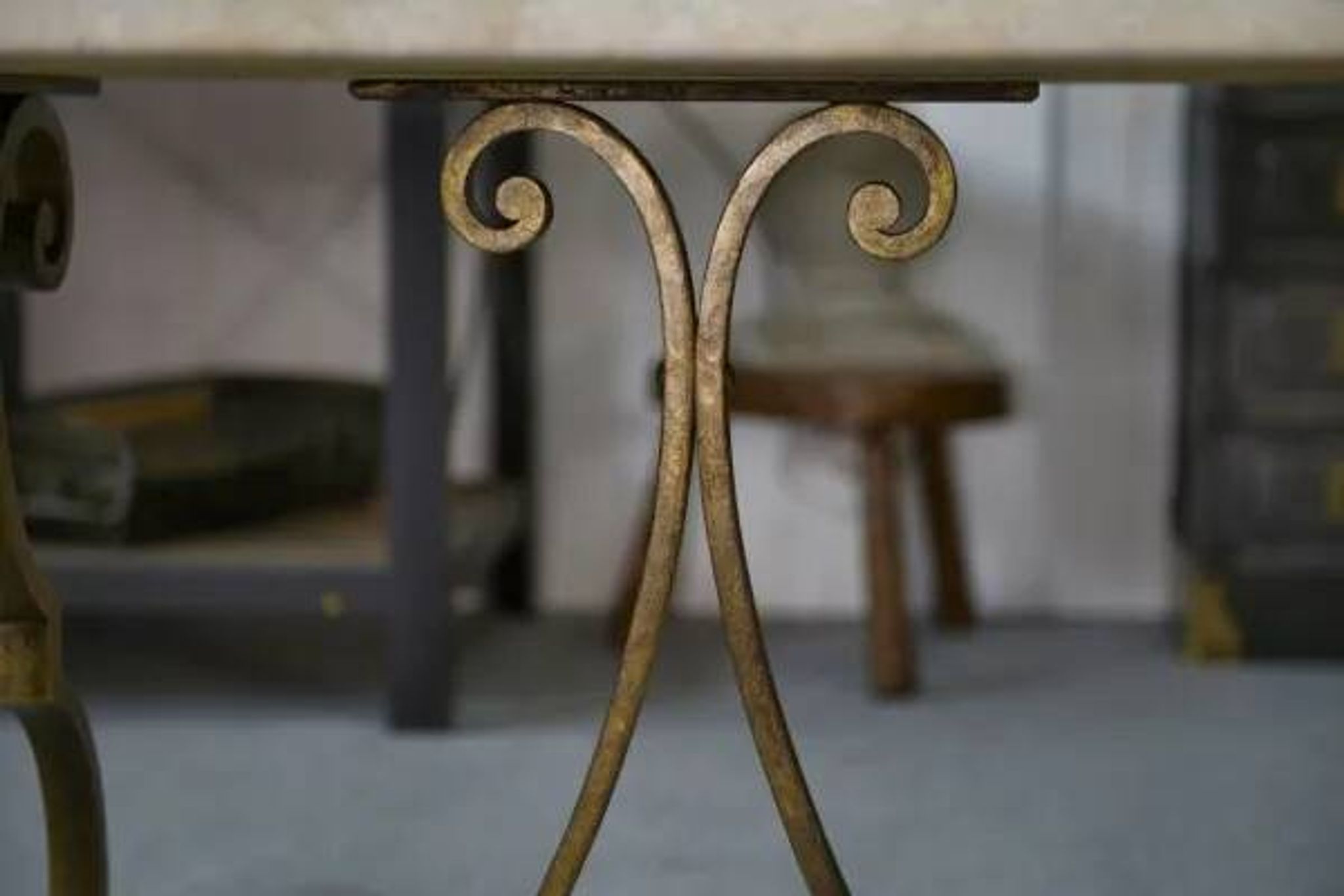 Side table with a gilt wrought iron base attributed to Gilbert Poillerat, with a travertine top, 1940s
