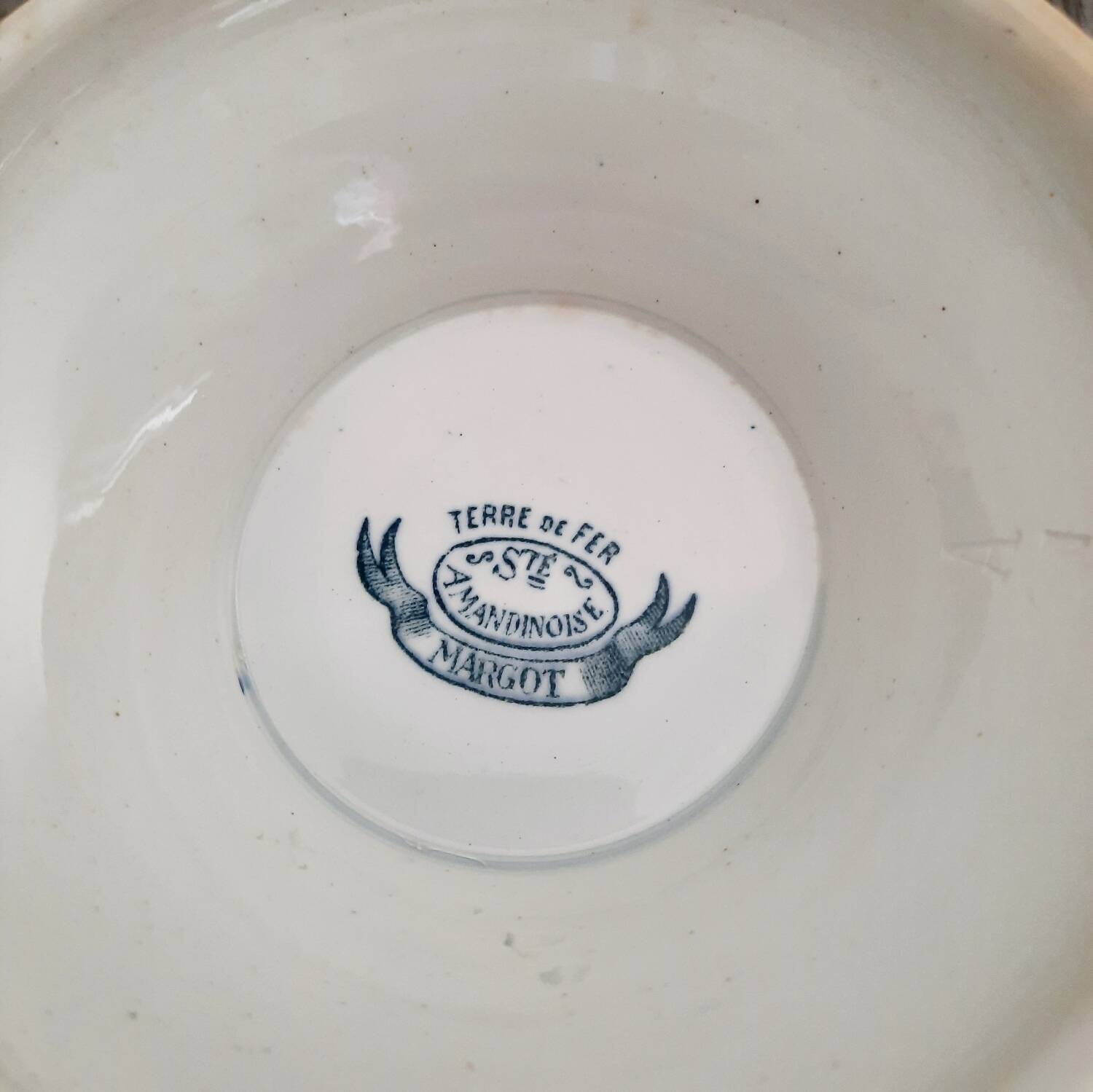 Old mismatched hollow plates in iron earth earthenware accompanied by a soup tureen