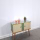 Vintage green DDR cabinet, model Libelle with glass top, slanted legs.