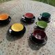 Coffee service composed of 5 cups and saucers in black earthenware and different colored interiors