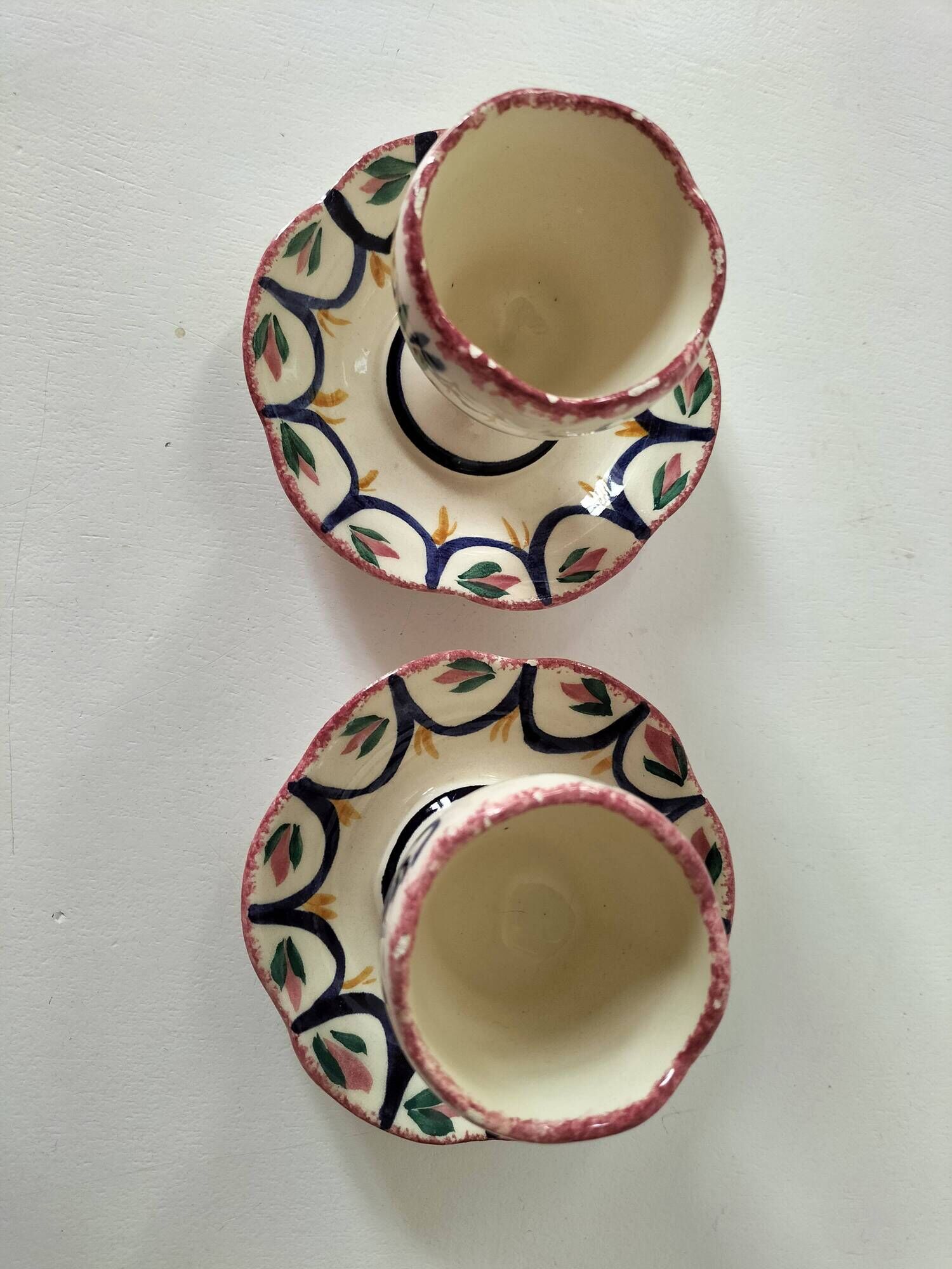 Pair of HB Quimper egg cups with integrated pedestal base, floral decoration