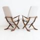 Pair of varnished wooden reclining armchairs, upholstered in lightweight fabric.