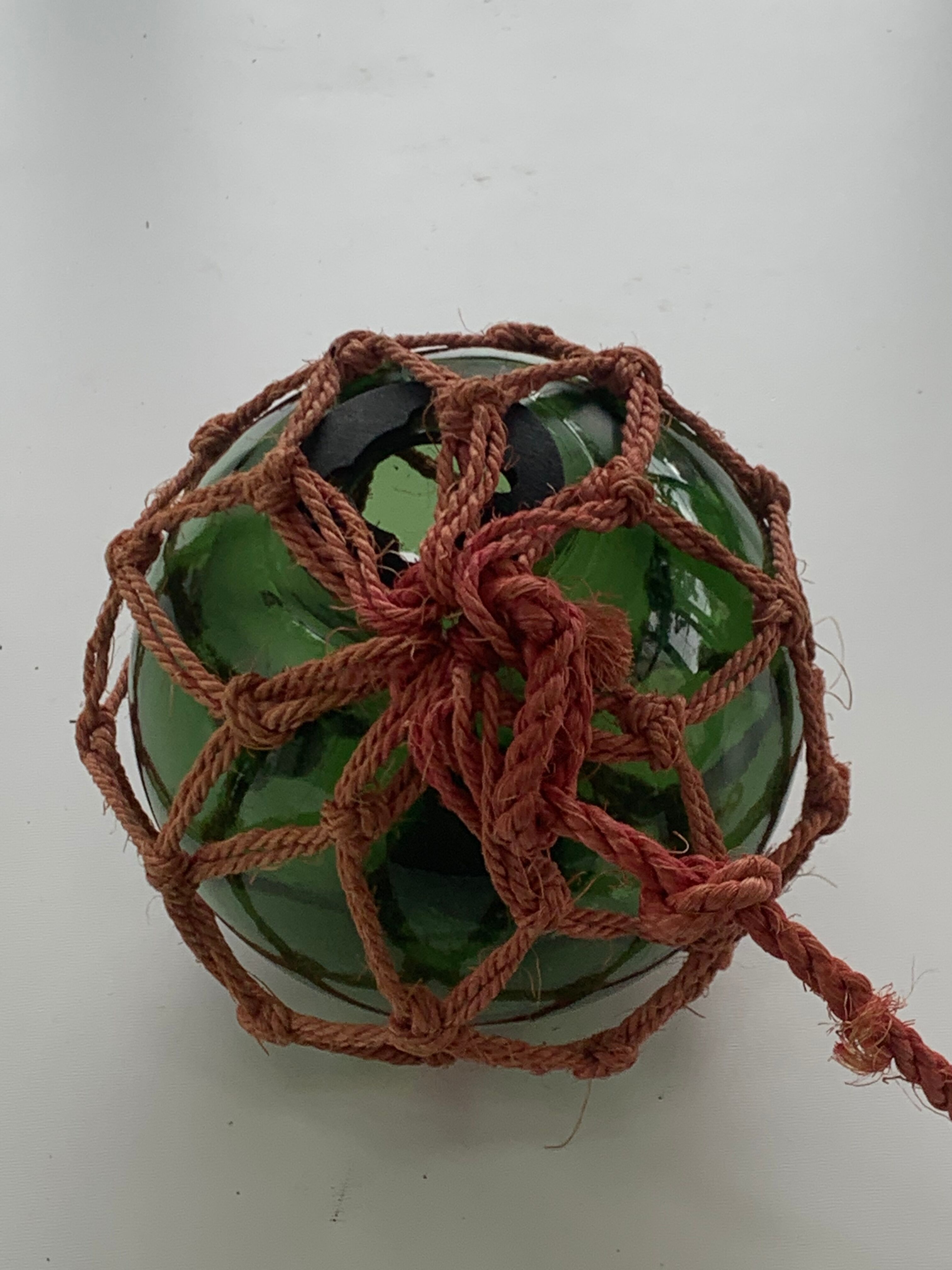 Globe, green glass float and vintage rope
