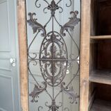Column storage unit with a sculpted metal door.