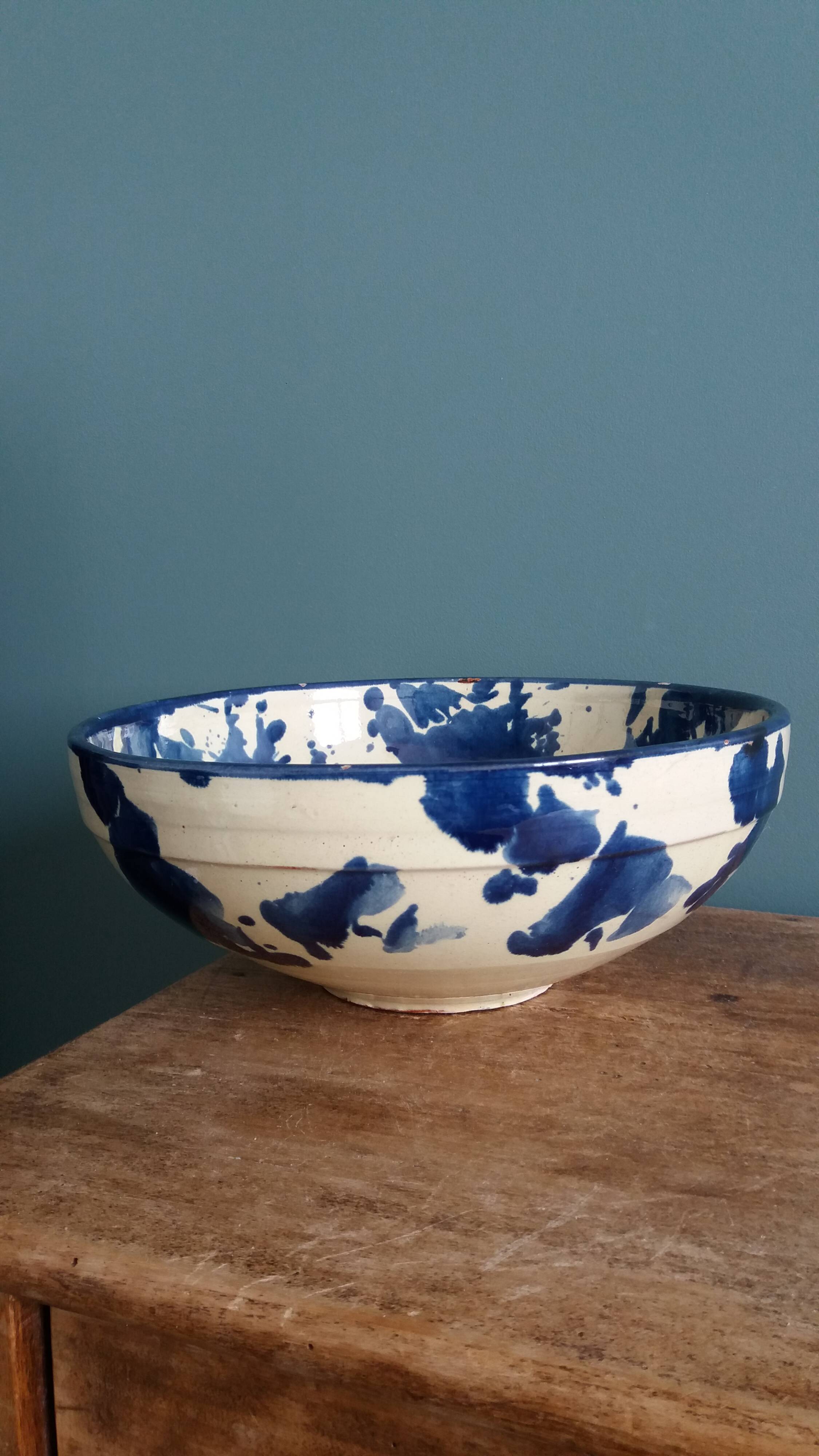 Empty pocket bowl in terracotta, glazed with "ink spots" design.