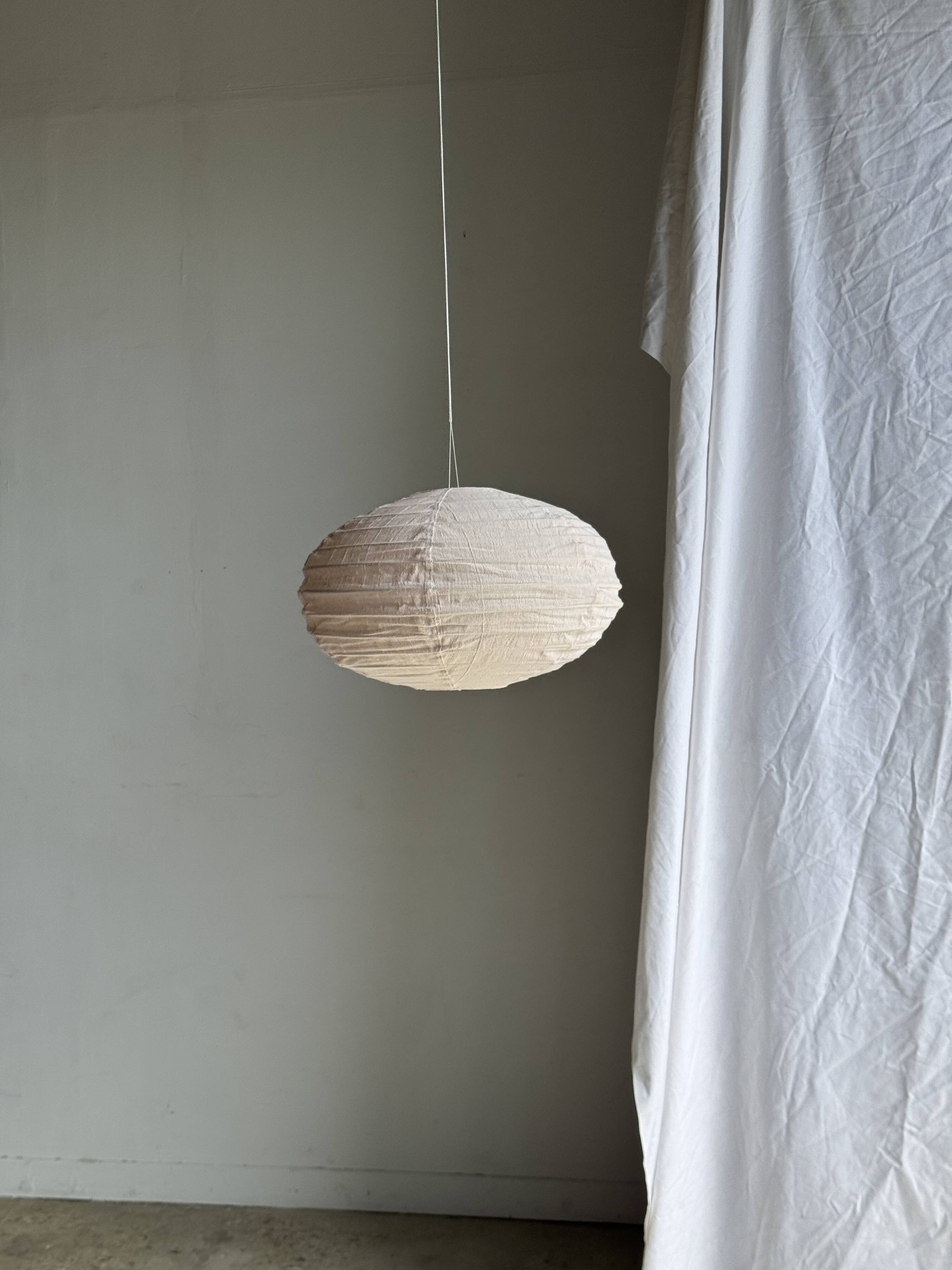 Average suspension in natural rattan and linen, Japanese-style, flattened oval in pink.