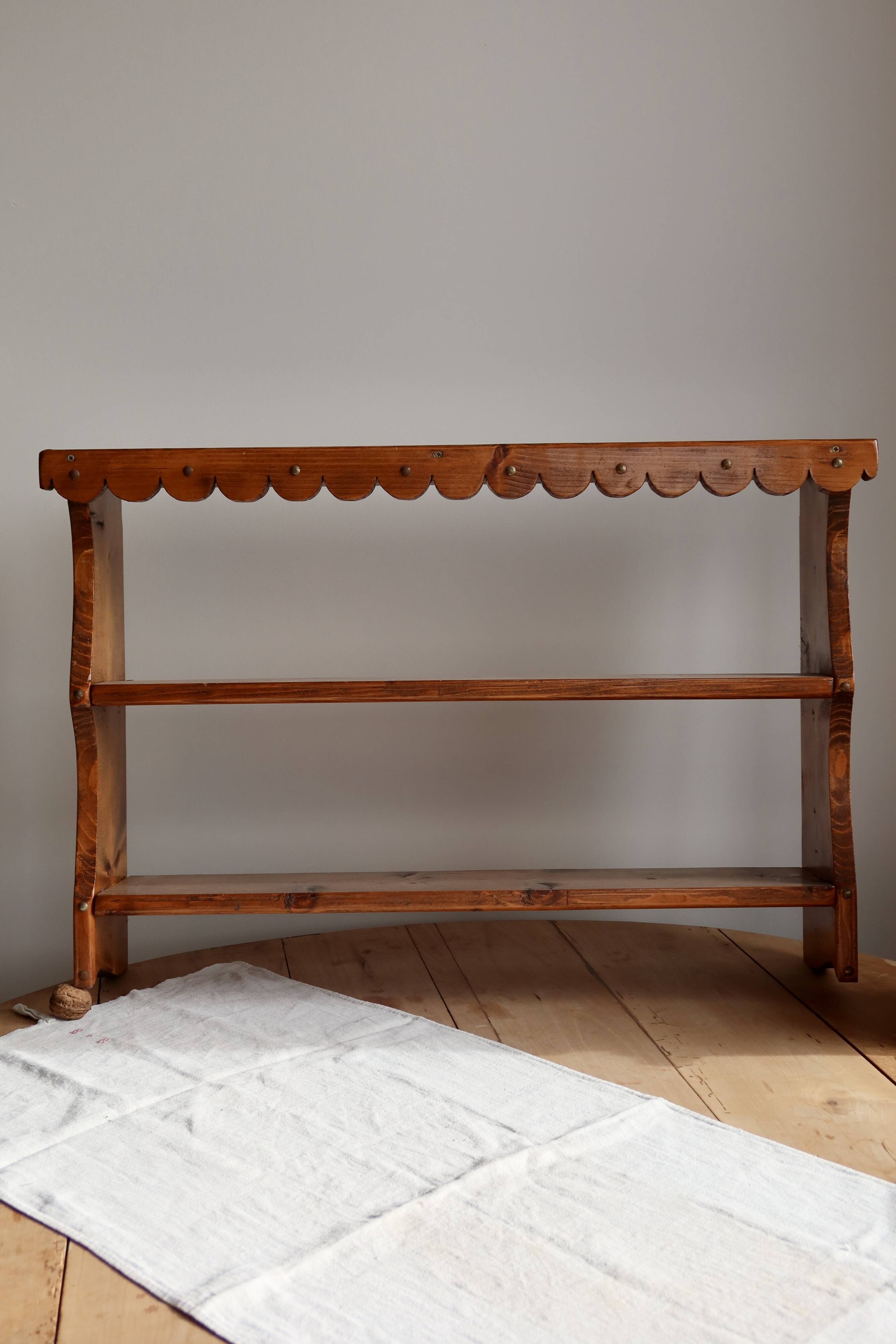 Vintage pine wall shelf with a scalloped front.
