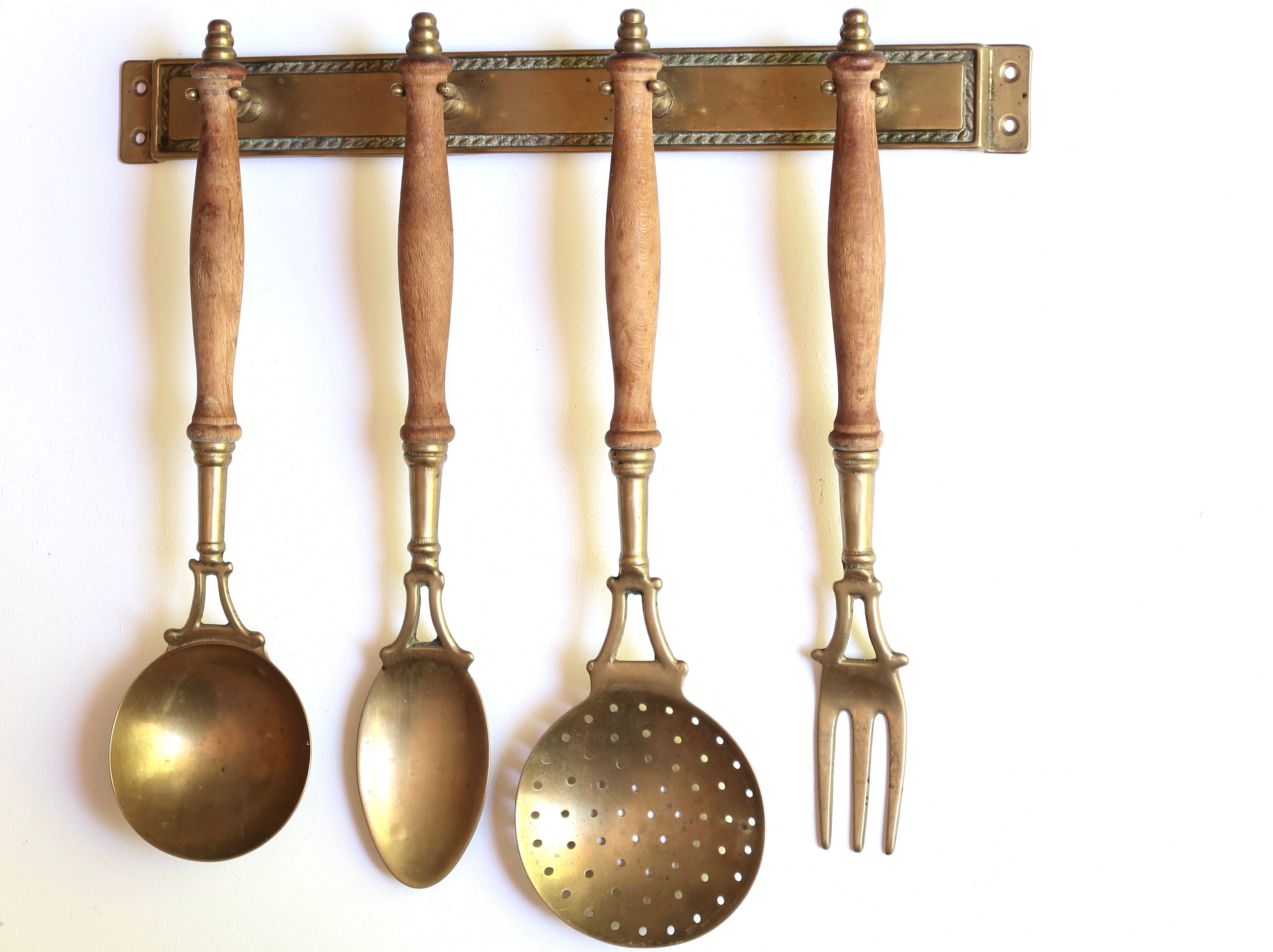Brass and wood kitchen utensils with wall display, 60s