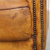 Comfortable, cozy armchair made of sheepskin leather with a proper finish with decorative nailheads