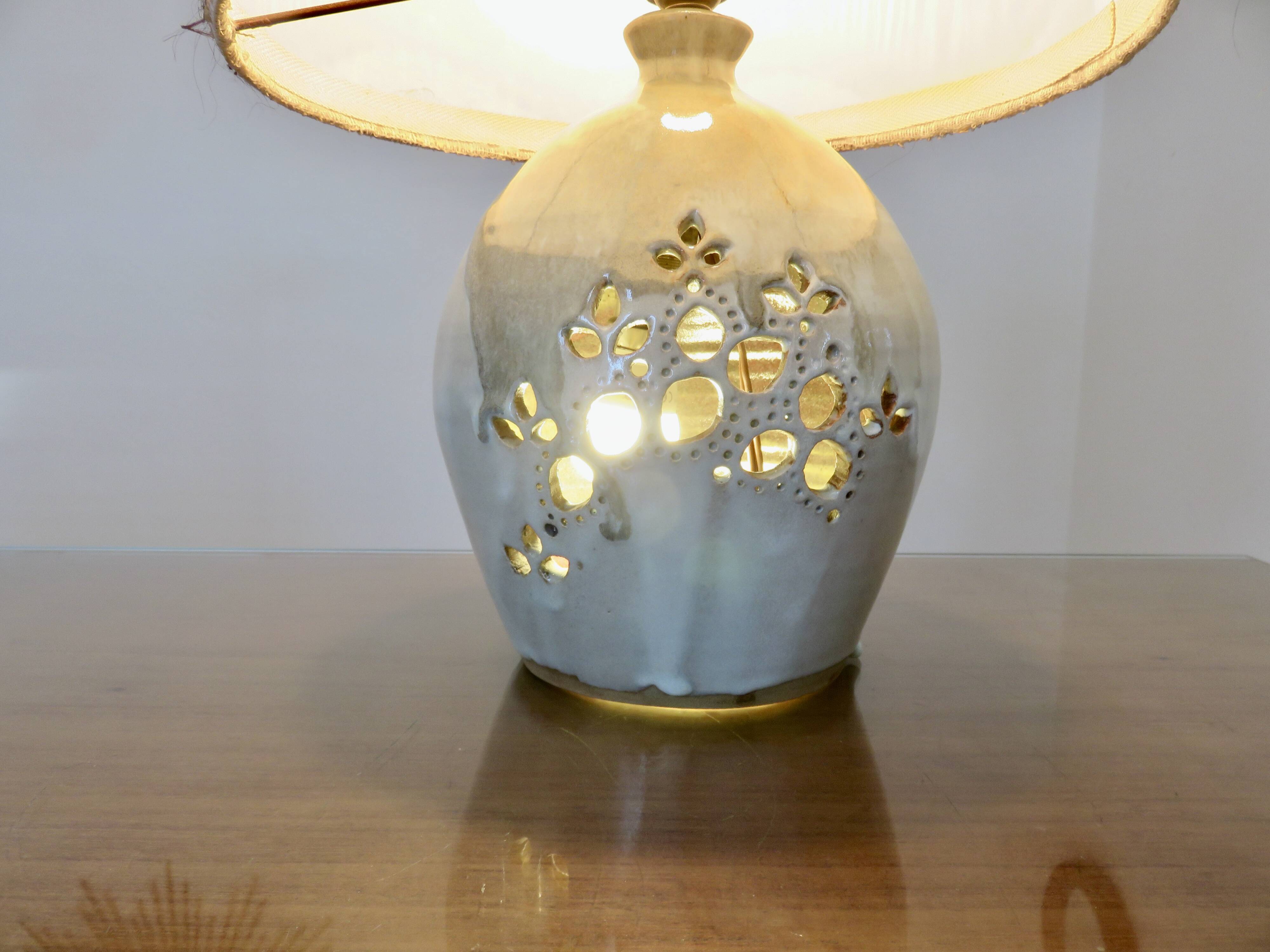 Ceramic lamp with double lighting and openwork design.
