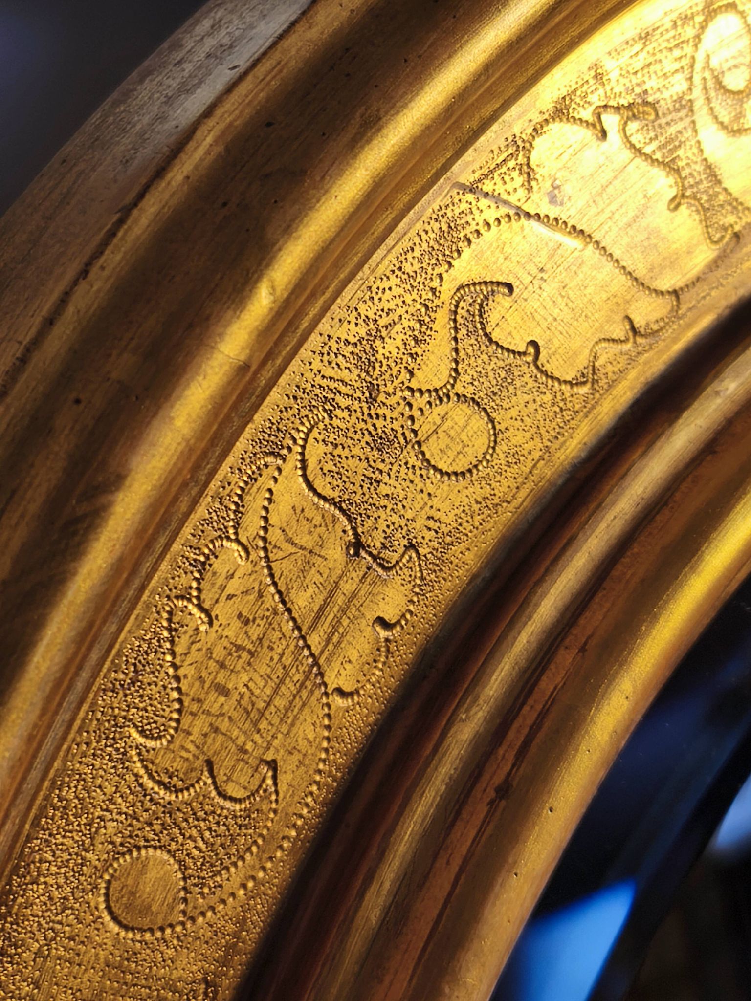 Florentine arched mirror in gilded wood with gold leaf.