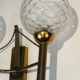 Pair of brass wall lights with glass globes. Around 1970.