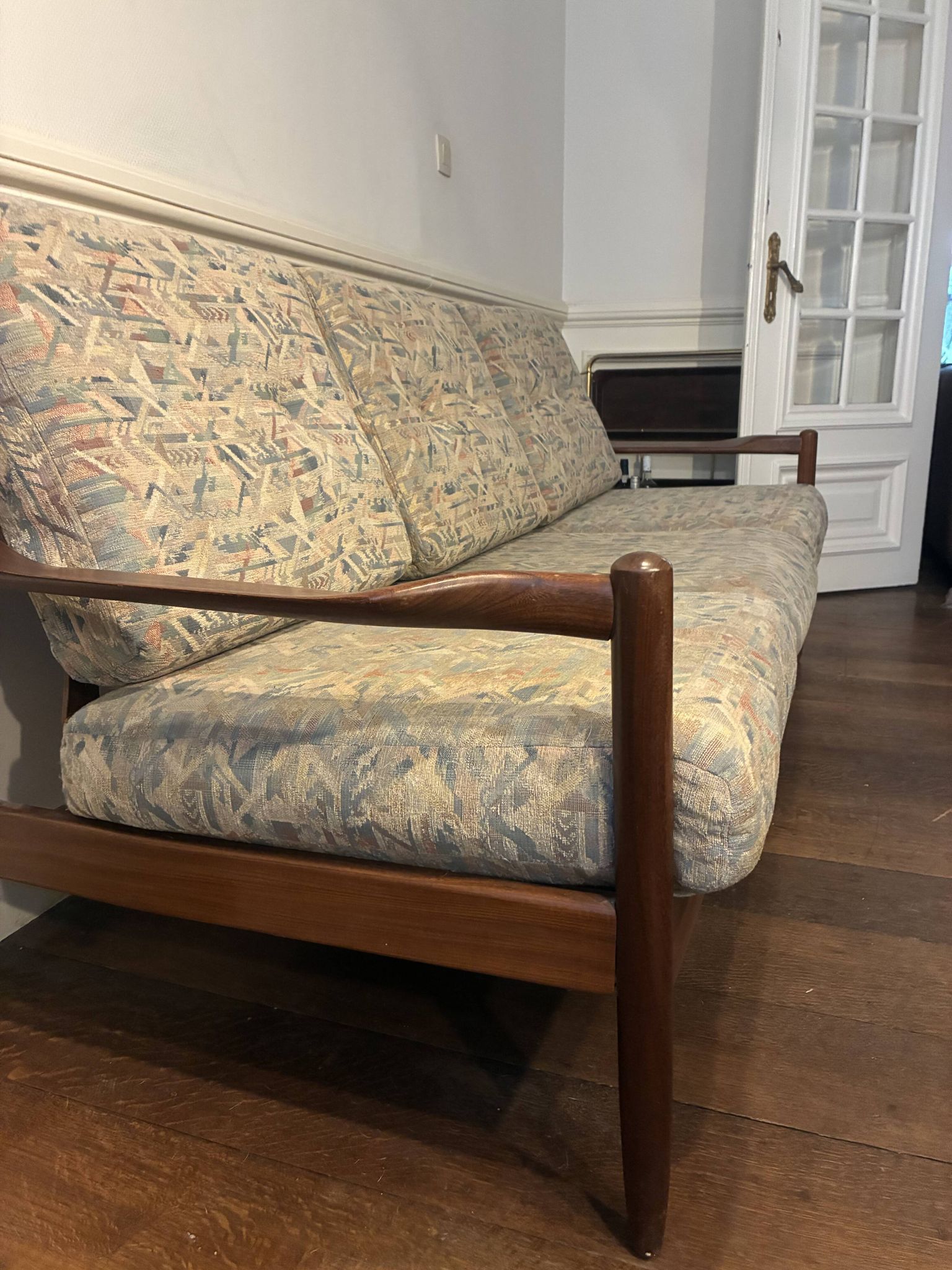 Vintage 3-seater wooden sofa with sculptural backrest.