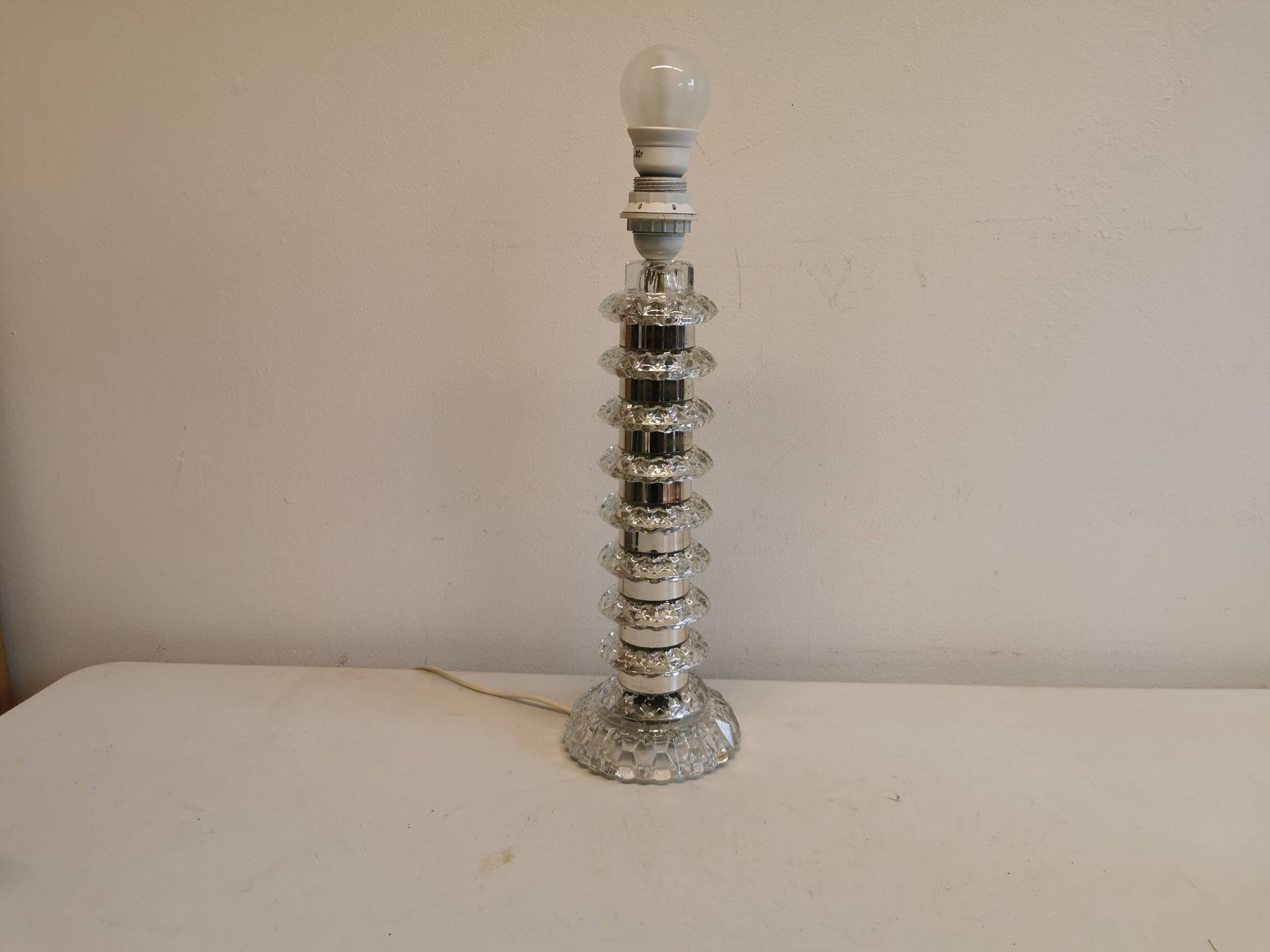 Table lamp made of transparent crystal glass and silver colored spacers.