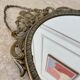 Oval mirror in gilded brass