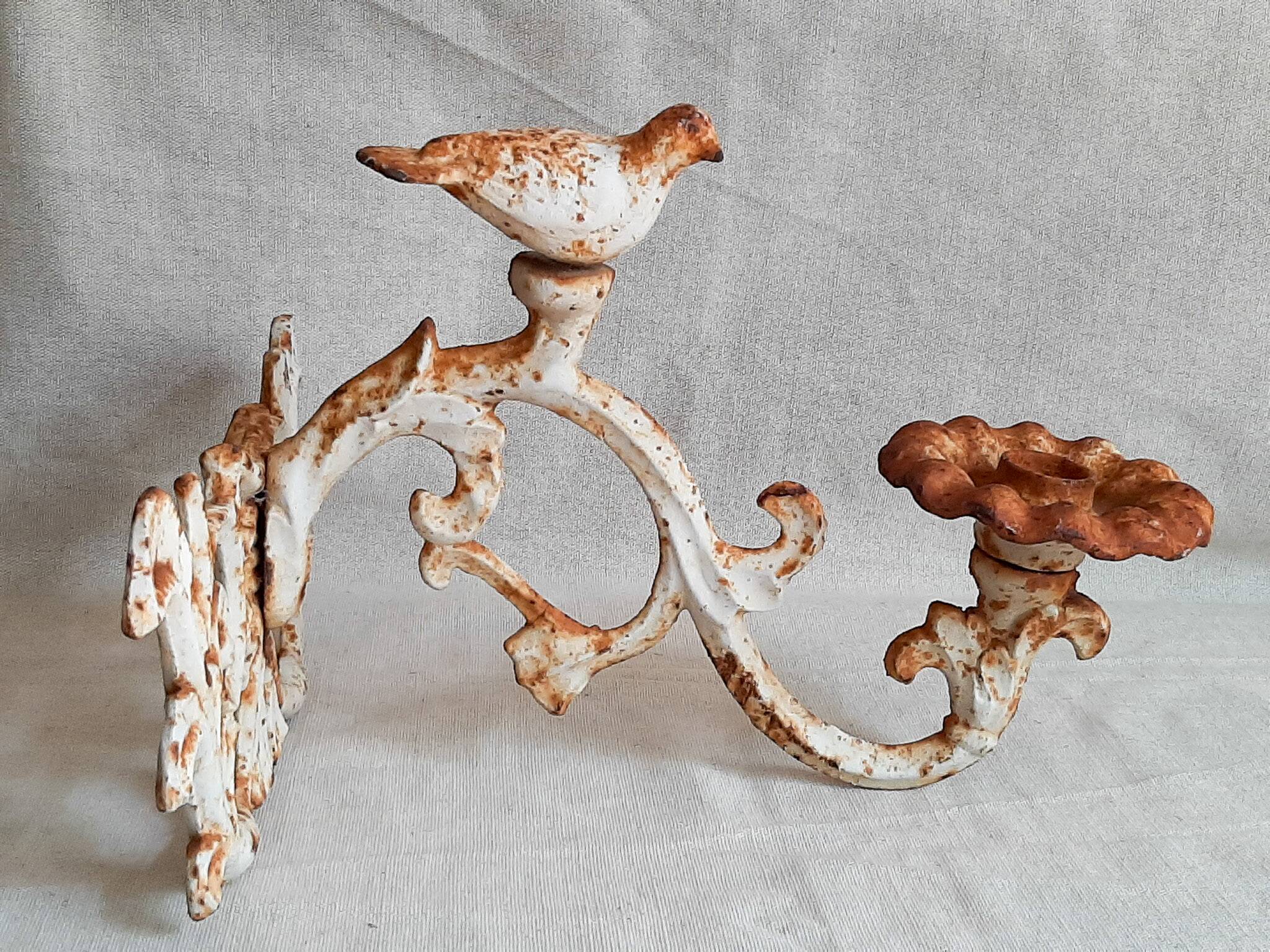 Wall lamp in antique cast iron with bird and scroll decorations.