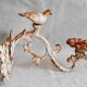 Wall lamp in antique cast iron with bird and scroll decorations.