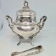 Silver metal sugar bowl with its clamp