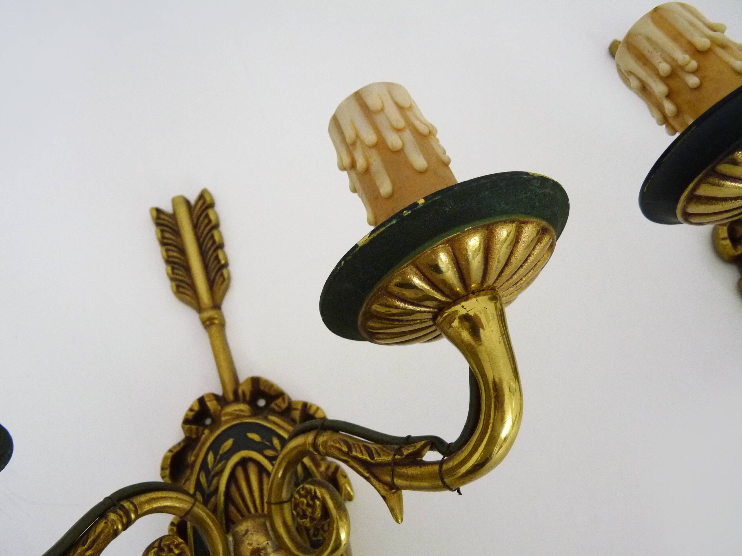 Pair of double-light Empire style arrow wall lights in bronze. Early 20th century