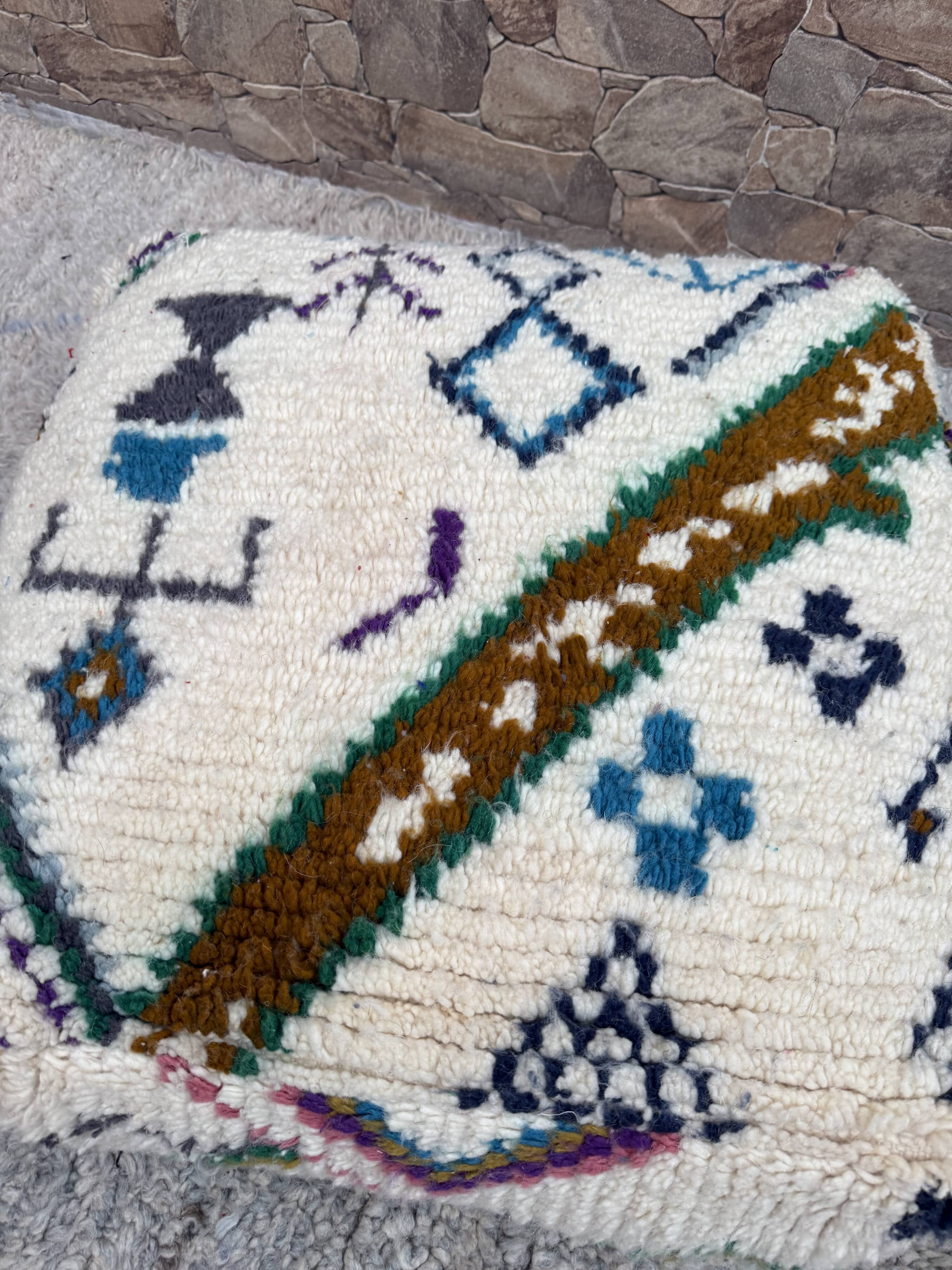 Berber floor pouf: Handwoven Moroccan wool cushion.