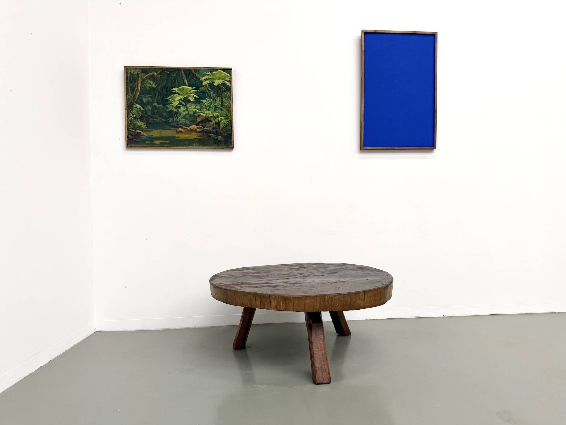 Brutalist coffee table in solid teak, monolithic slab, tripod base.