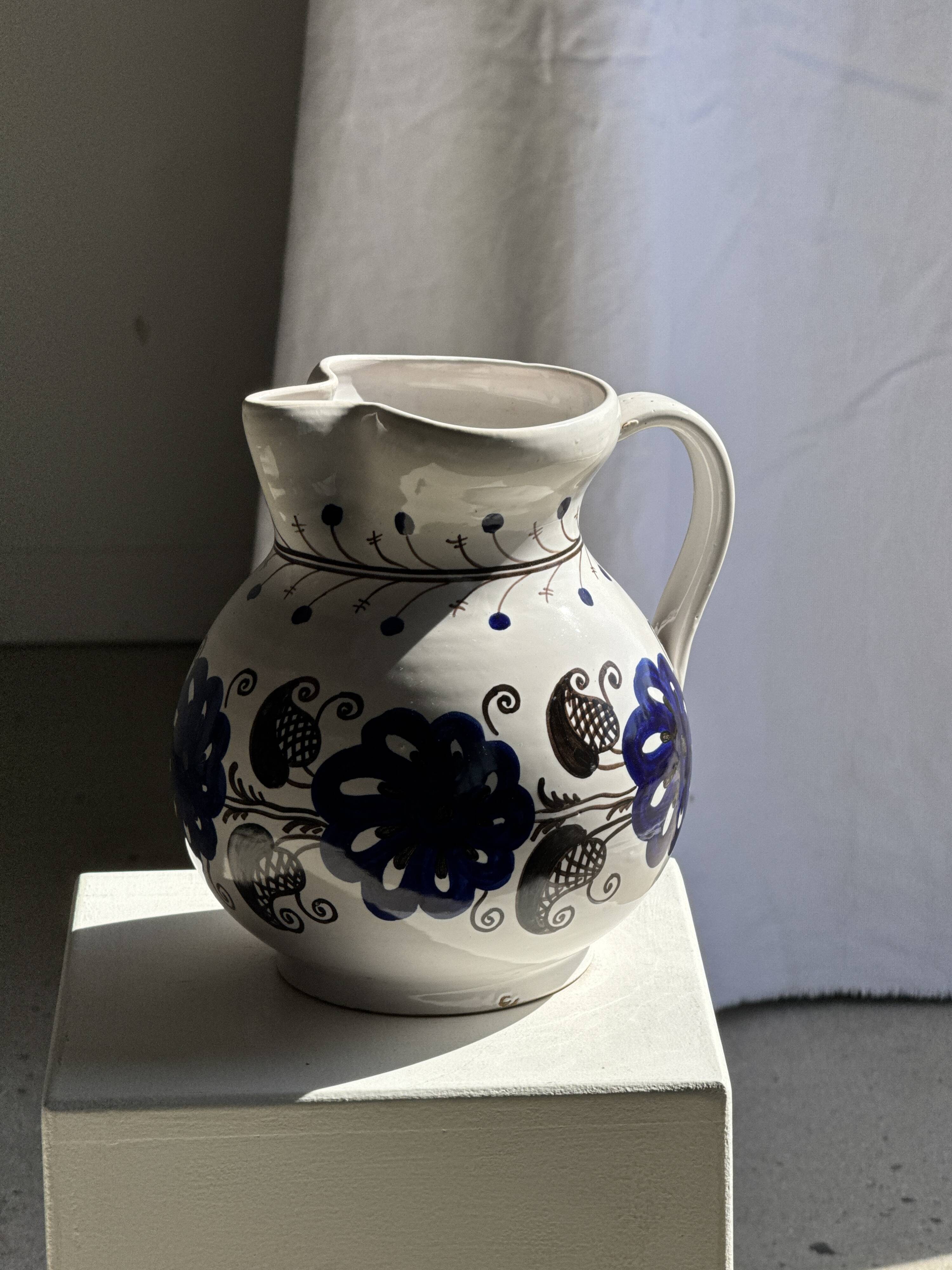 Very large vintage ceramic carafe in white glazed with blue floral decoration.