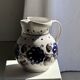 Very large vintage ceramic carafe in white glazed with blue floral decoration.