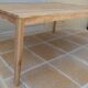 Large natural wood table with rectangular top supported by legs