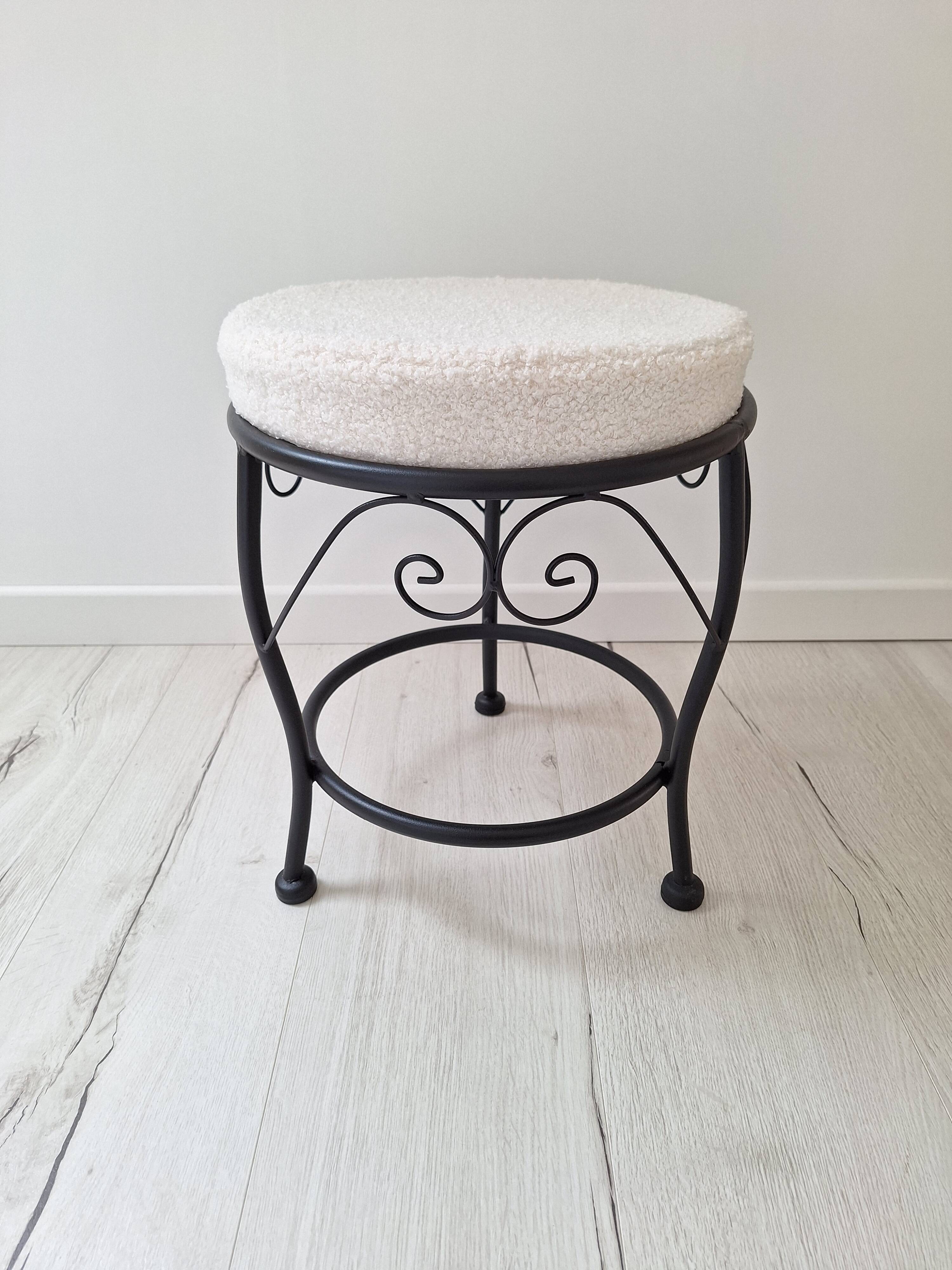 Black iron stool/pouf with its boucle fabric cushion.