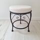 Black iron stool/pouf with its boucle fabric cushion.