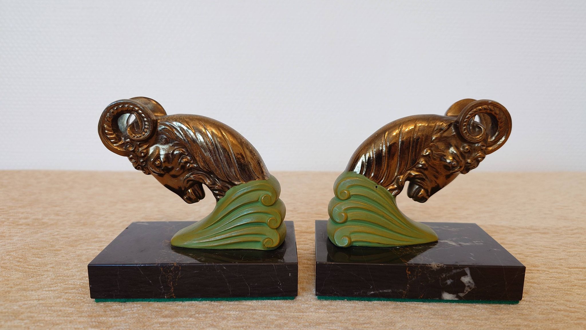 Art Deco pair of bookends with ram's heads, patinated metal and black marble.