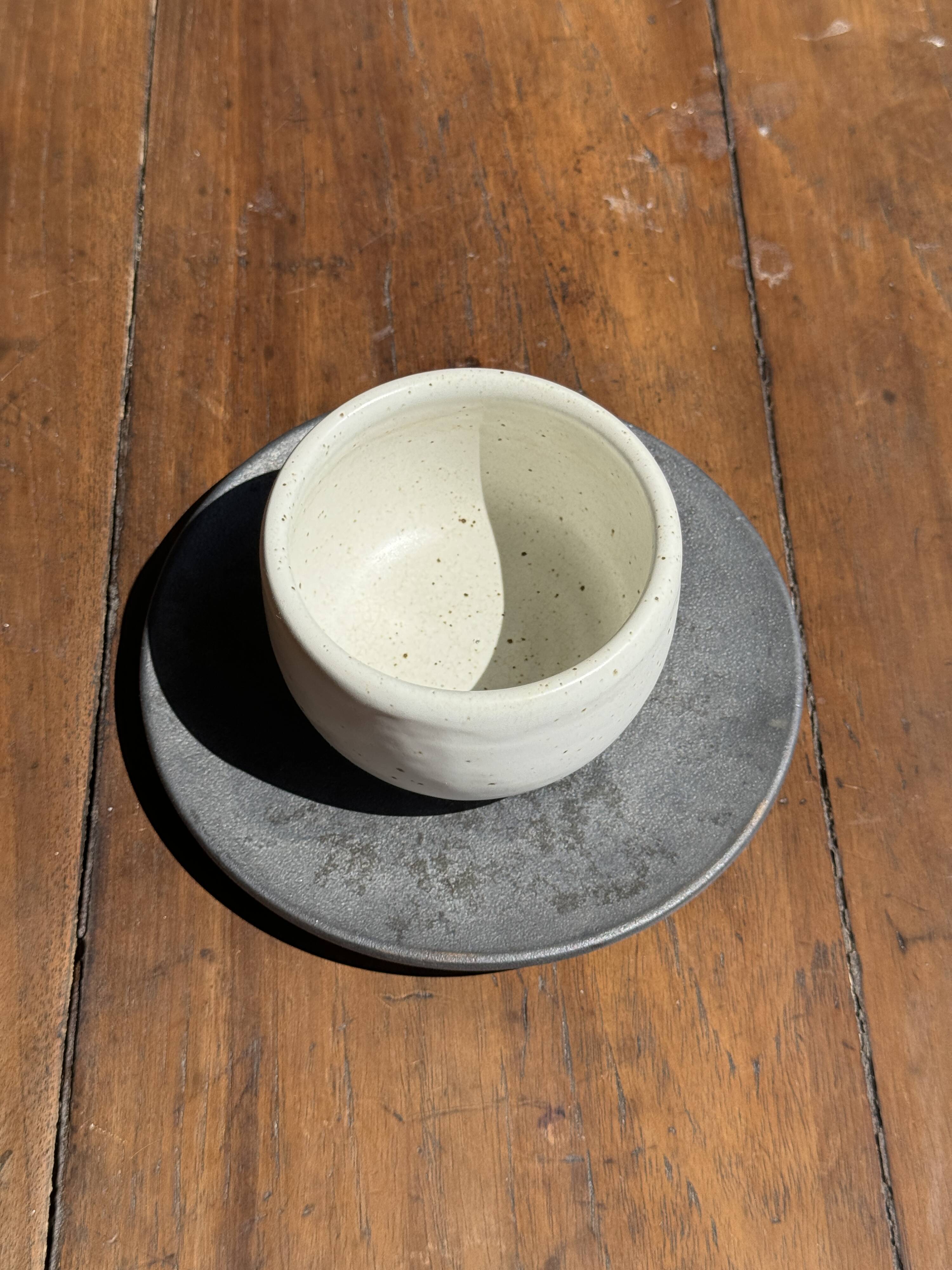 White Indonesian ceramic cup and gray saucer