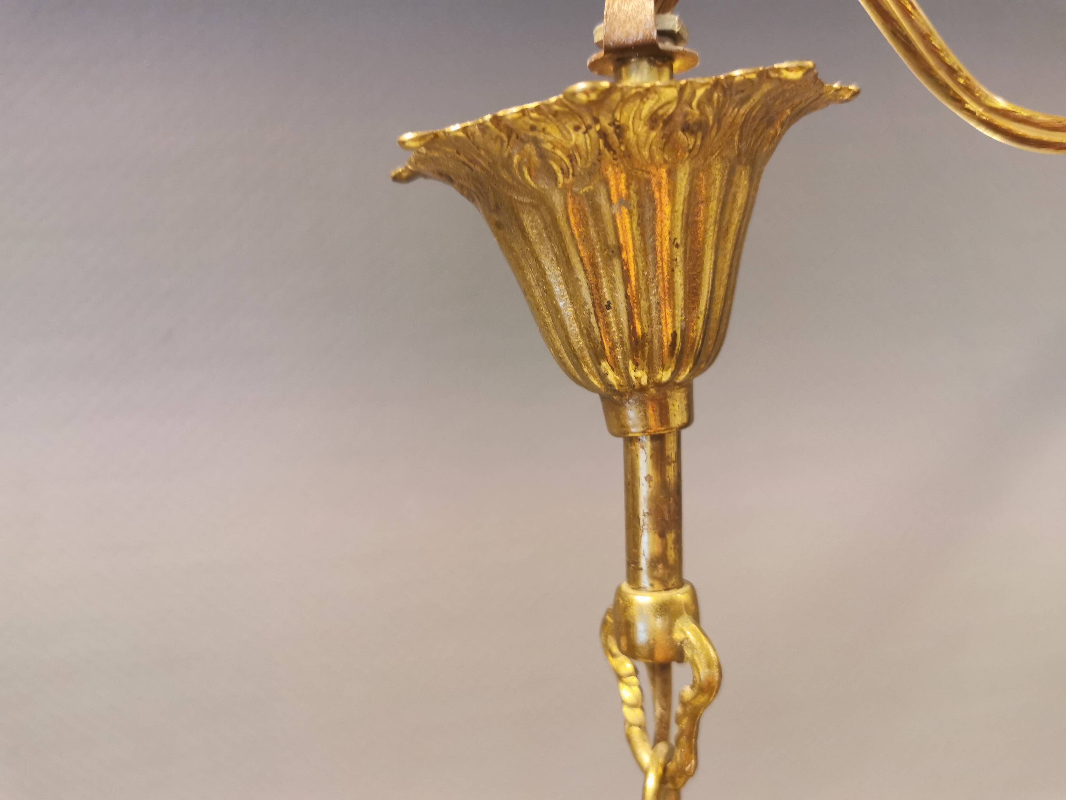 Older brass alloy chandelier with three light sources.